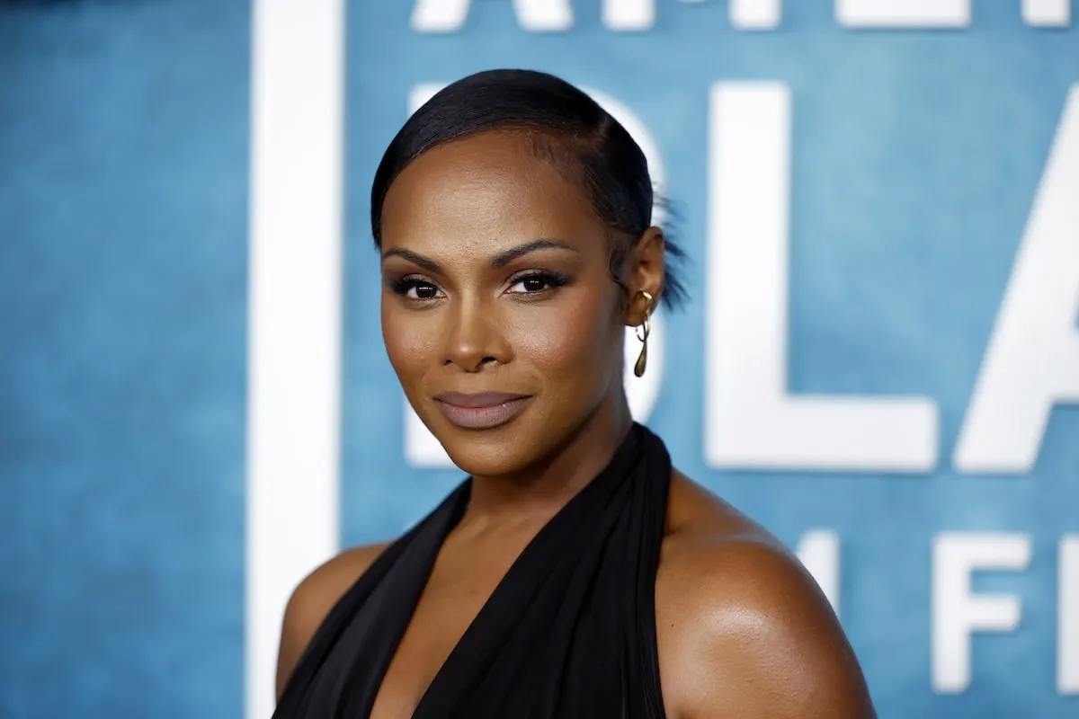 Wearing a black gown with a plunging necklace, Tika Sumper poses for photos while walking the red carpet before the American Black Film Festival