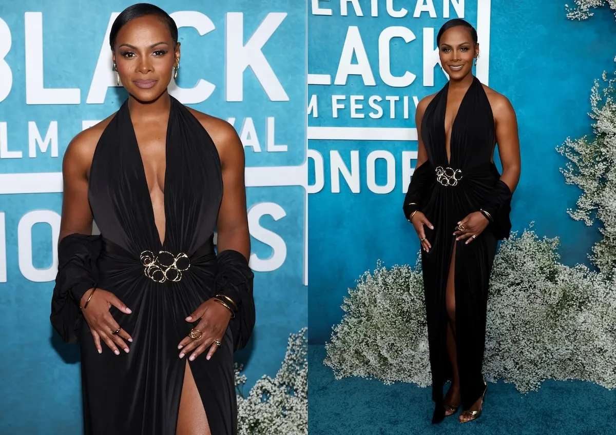 Wearing a black gown with a plunging necklace, Tika Sumper poses for photos while walking the red carpet before the American Black Film Festival