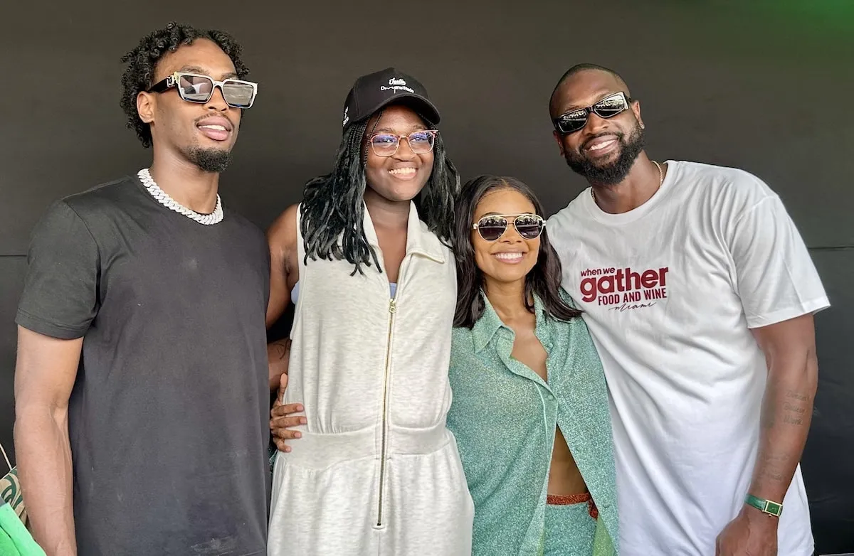 Wearing a mint green matching set, Gabrielle Union smiles with Dwyane Wade and his kids, Zaire and Zaya, at a Miami festival in 2024