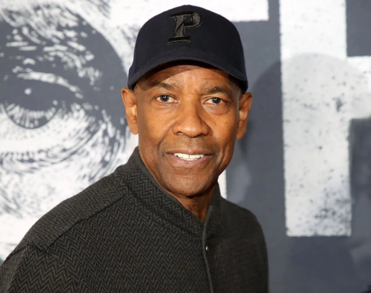 Denzel Washington posing at the premiere of 'Othello' in a black shirt and cap.