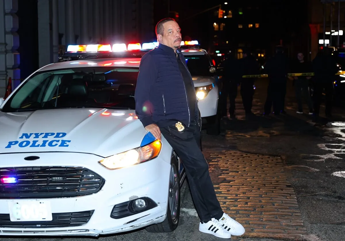 Ice-T posing next to a police car on the set of 'Law & Order SVU'.