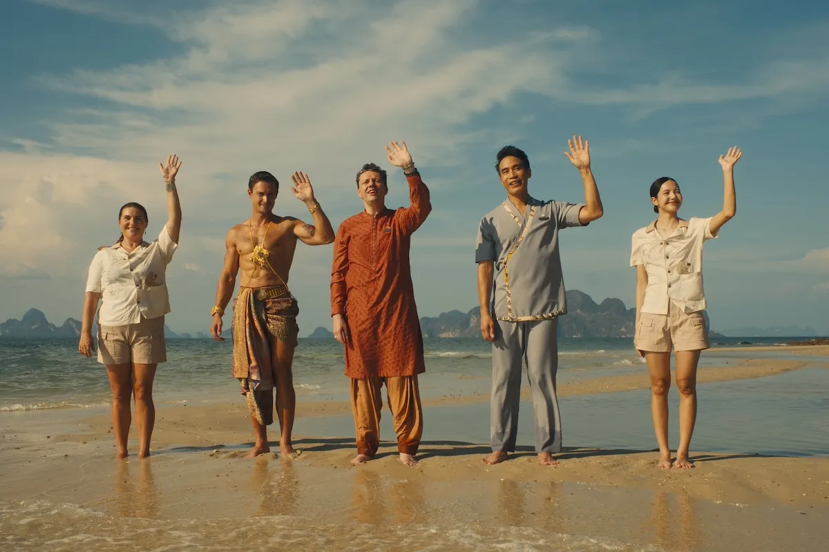 Group of people standing on a beach and waving in 'The White Lotus' Season 3